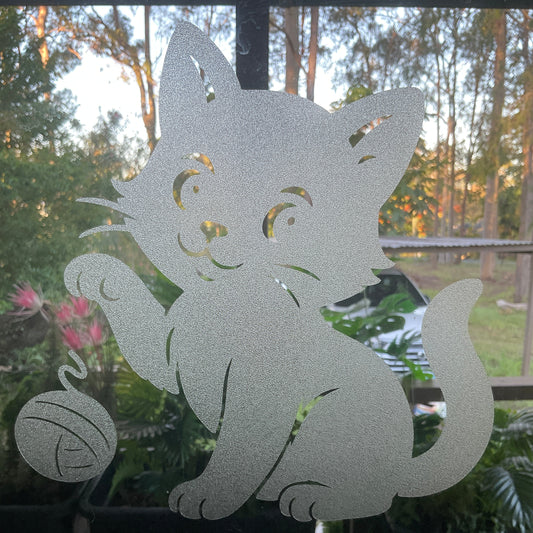 Decorative glass with a cat design and a ball of yarn.